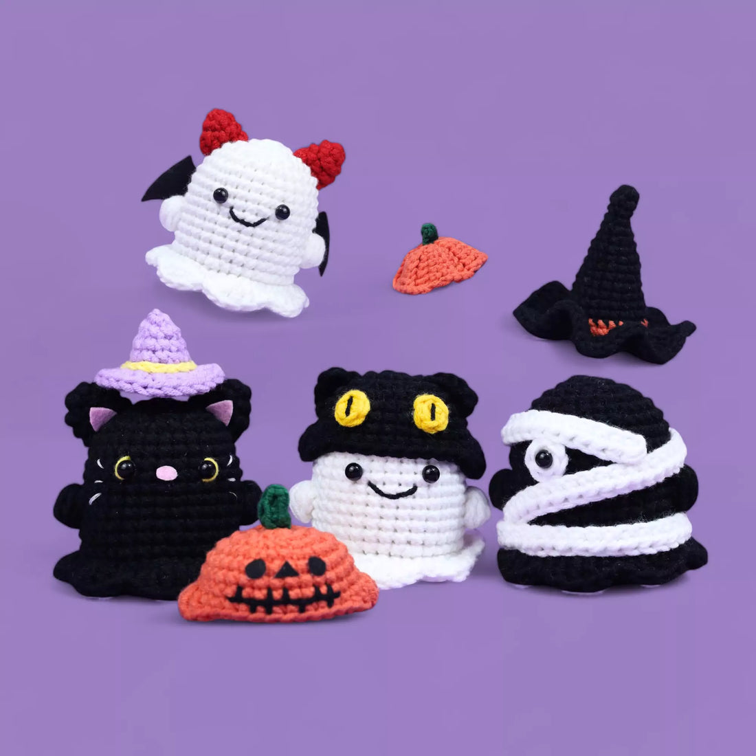 A collection of hand-crocheted Halloween patterns ghosts with various hats and accessories, including pumpkins and black cats, in a 4-in-1 Ghosts Halloween Crochet Pattern.