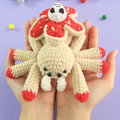 Hand holding Skull Spider Crochet Pattern on a purple background